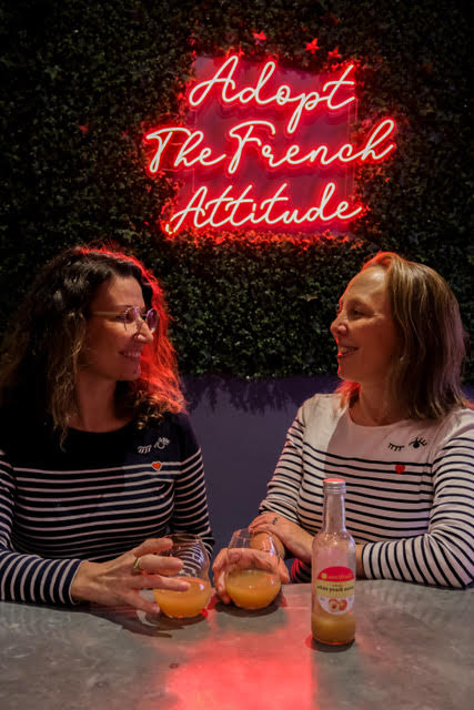 two women wearing french stripe shirts in a french restaurant