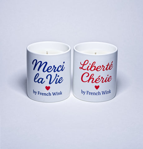 Two white candles with French text and 'by French Wink' branding on a light gray background.