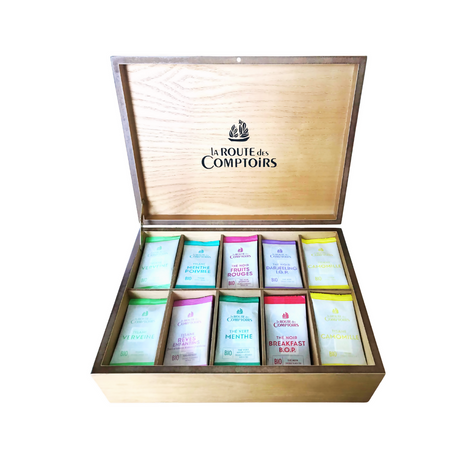 Wooden tea box with 'La Route des Comptoirs' branding and assorted tea packages inside.