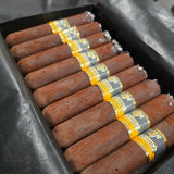 Chocolate cigars with yellow bands in a black tray