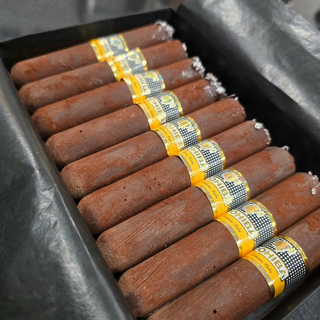 Chocolate cigars with yellow bands in a black tray