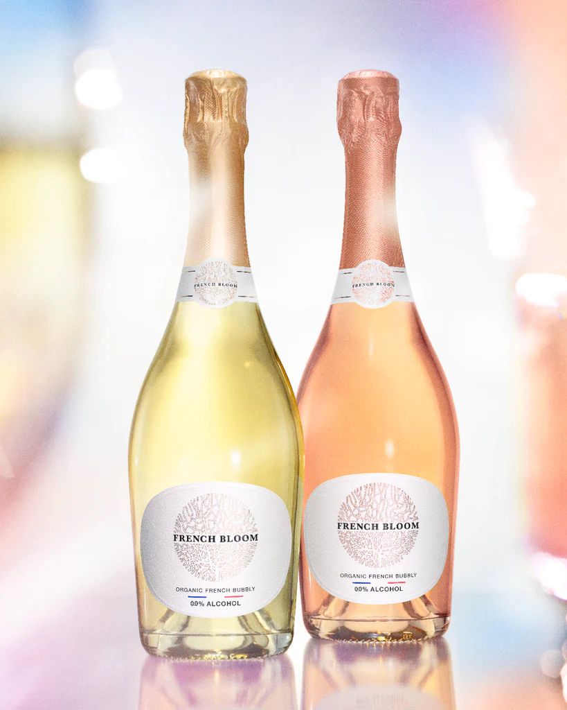 Two bottles of French Bloom sparkling wine, one white and one pink, on a blurred background.