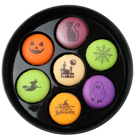 Halloween-themed macarons in a black dish