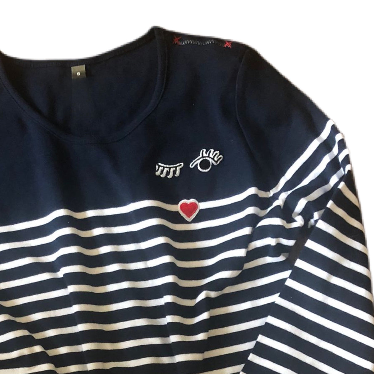 Close up on the embroidery of the french stripes top